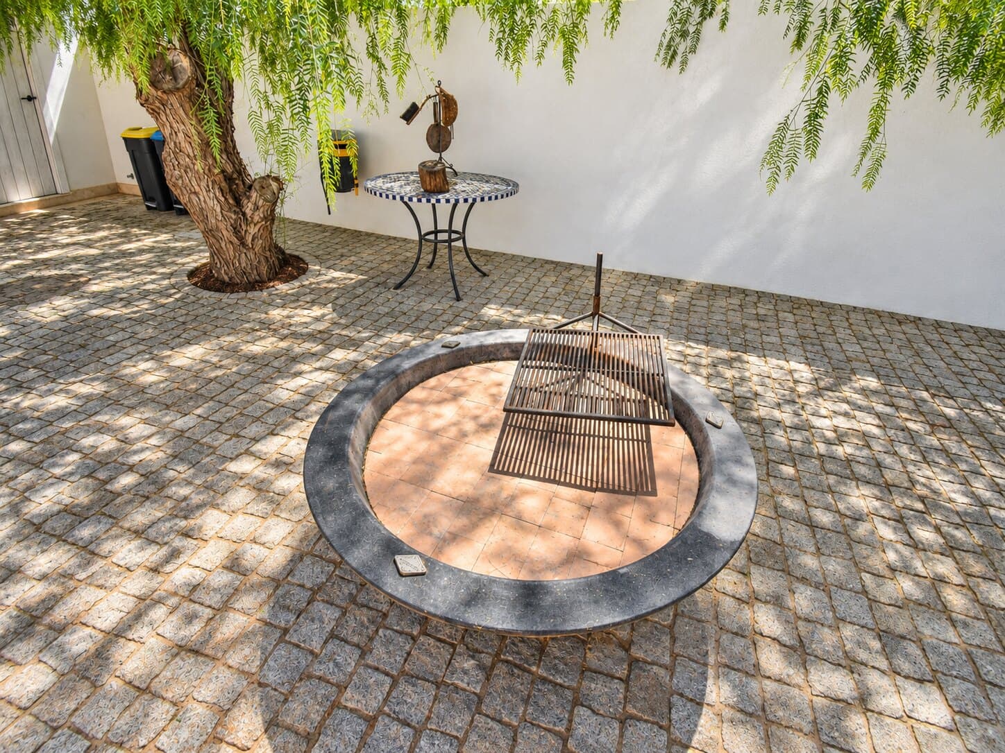Hogar circular en el patio empedrado del cortijo