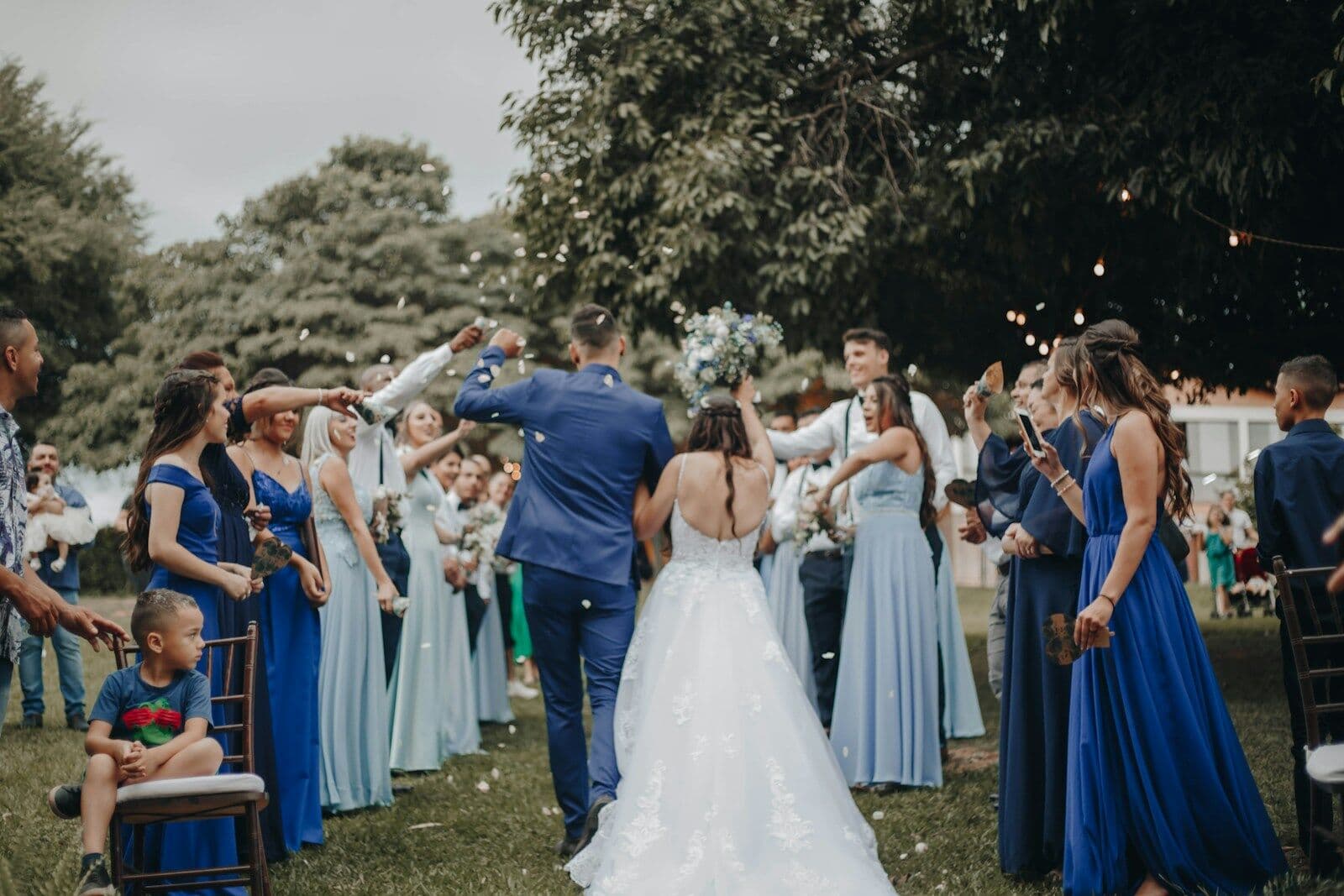 Novia caminando entre invitados y niños en una boda al aire libre