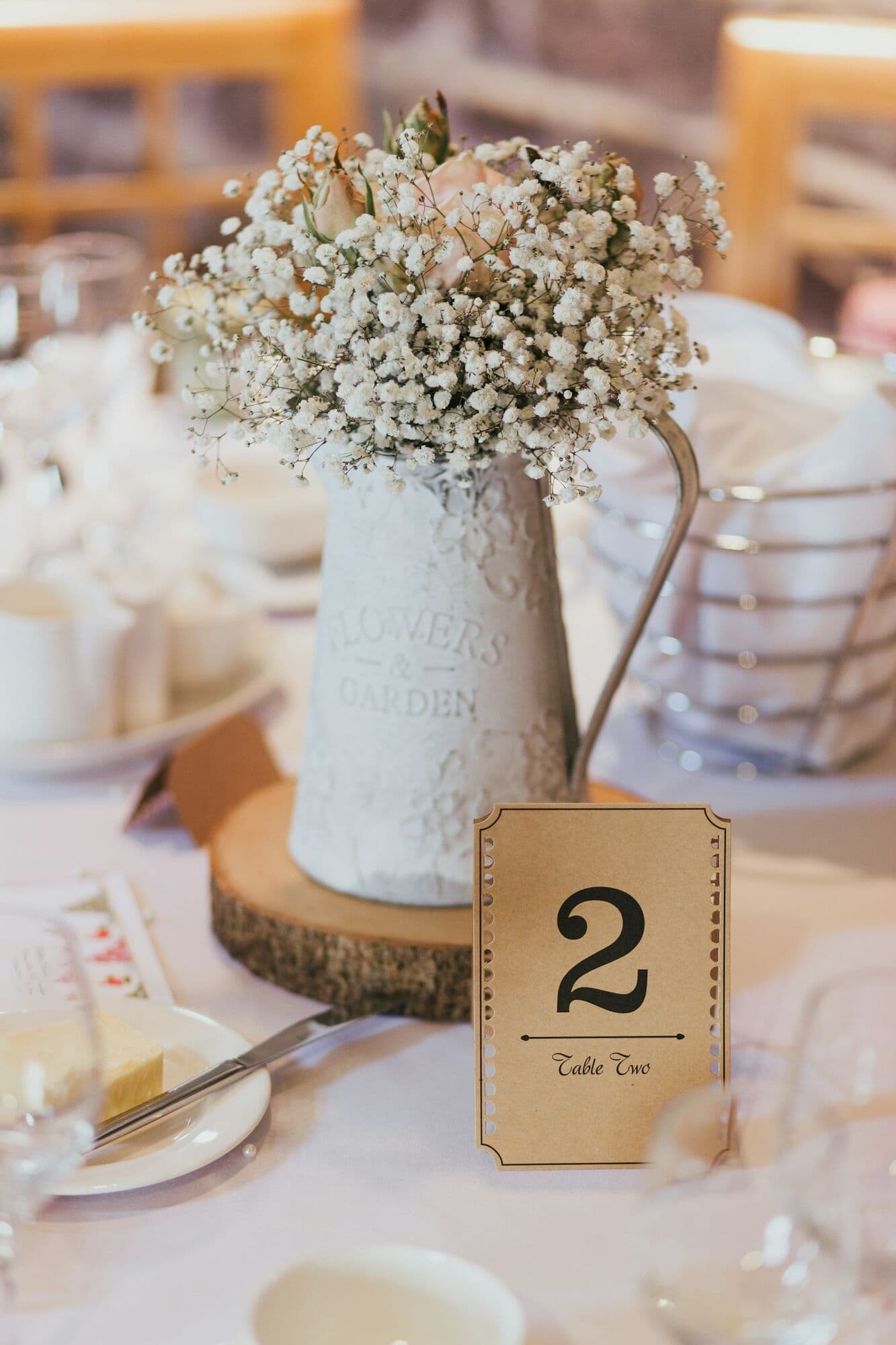 Centro de mesa con flores blancas y número de mesa