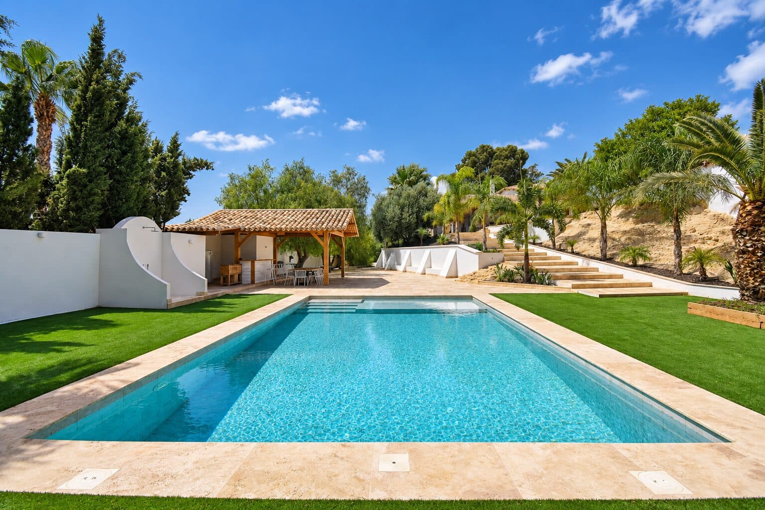 Piscina del cortijo con el porche al fondo