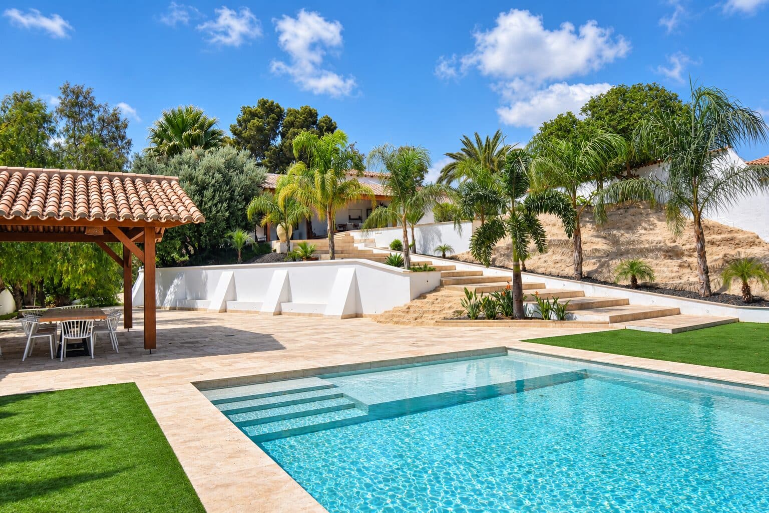 Jardín y piscina del cortijo rodeados de palmeras